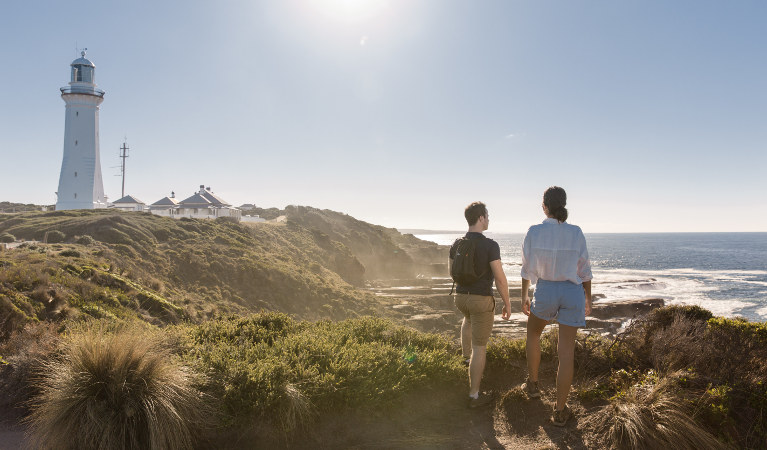 A couple takes in the coastal views of Green Cape Lightstation in Beowa National Park. Photo: Tim Clark/DNSW