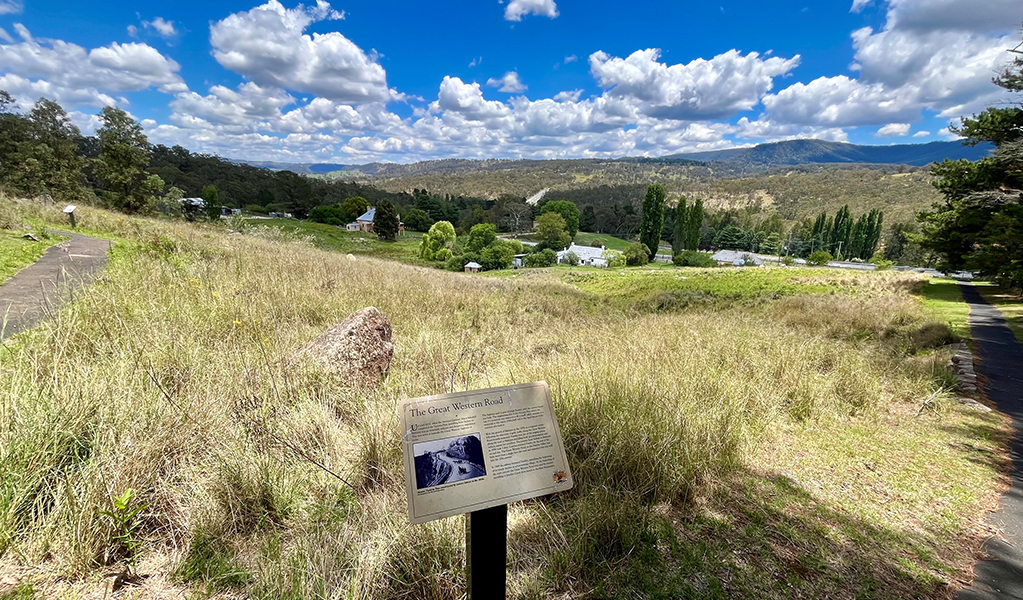 Beautiful view of rolling hills looking down into Hartley village and historic signage along a walk. Credit: Natasha Webb &copy; Natasha Webb/DCCEEW