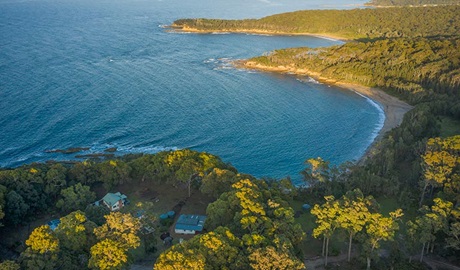 Aerial view of Judges House (right), neighbouring Yellow Rock Beach House and the coastline, Murramarang National Park. Photo: John Spencer ©DPIE